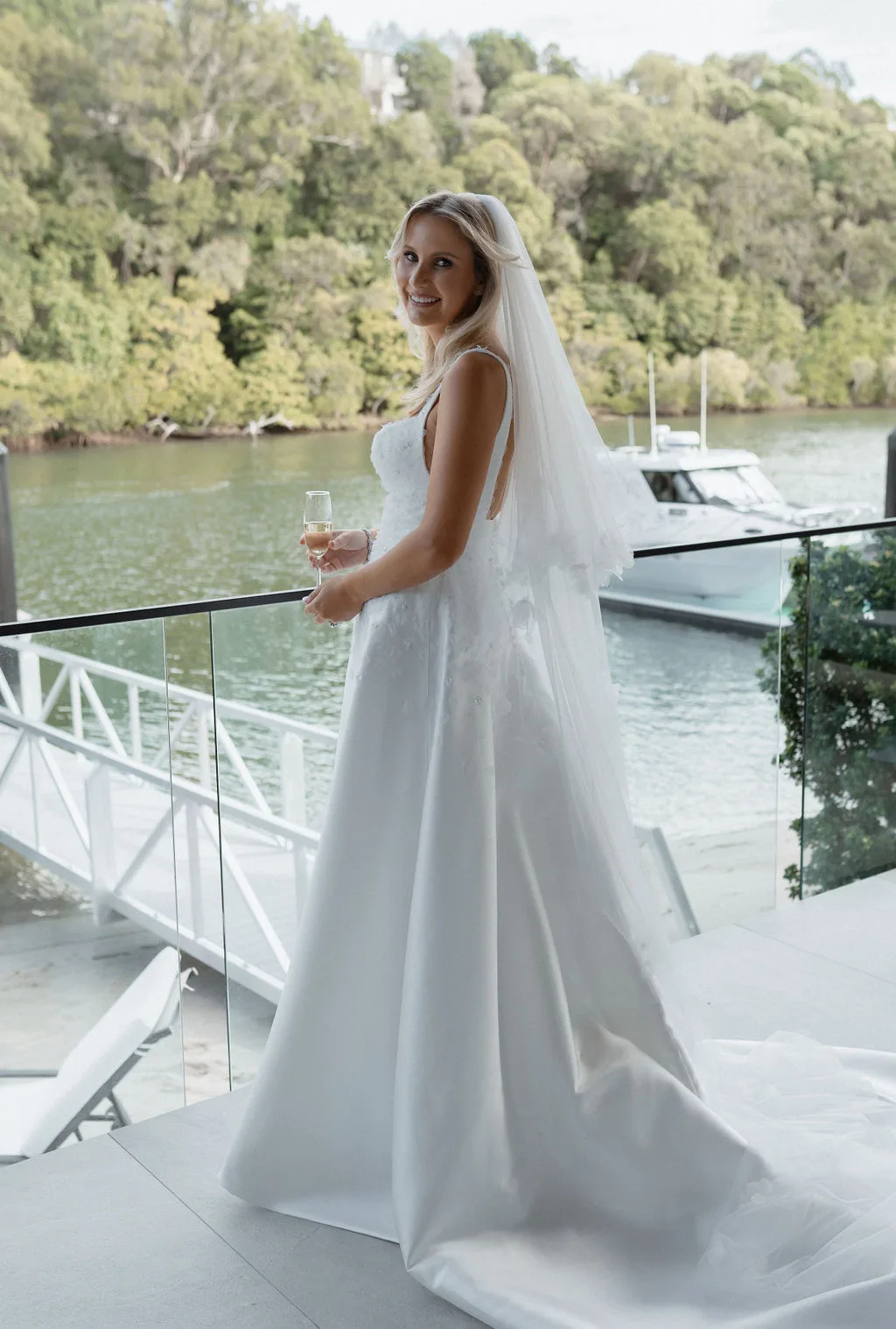 Bride with champagne on the waterfront deck at 33 Witta